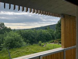 a porch with a view of a field and trees at Apartmán na Zadově in Stachy