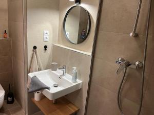 a bathroom with a sink and a shower with a mirror at Apartmán na Zadově in Stachy