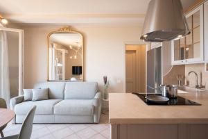 Il dispose d'une cuisine et d'un salon avec un canapé et une table. dans l'établissement Zefiro Apartments, à San Vincenzo