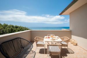 a balcony with a table and chairs and the ocean at Zefiro Apartments in San Vincenzo