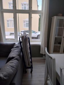 a couch in a living room with a large window at 1St Floor Oasis - Parking/WiFi in Stavanger
