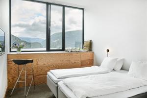 a bedroom with two beds and a large window at Energihotellet in Nesflaten