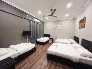 a room with three beds and a ceiling fan at Melur Inn, Tok Jembal in Kampong Tanjong Gelam