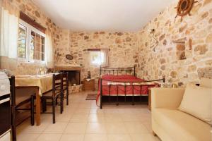 a bedroom with a bed in a stone wall at Lithahiro stone house in Keri