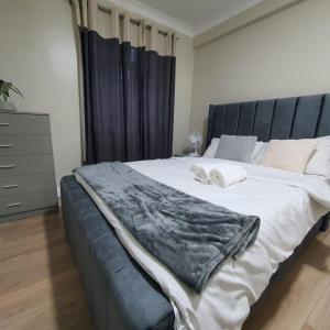 sypialnia z dużym łóżkiem z czarnym zagłówkiem w obiekcie Bungalow in leafy area w mieście Upminster
