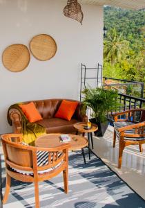 a living room with a couch and a table and chairs at Sunset Hilltop Ocean View 2bd House in Haad Tian
