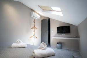 a bedroom with two white towels on a bed at Parthenis Riviera Hotel in Athens