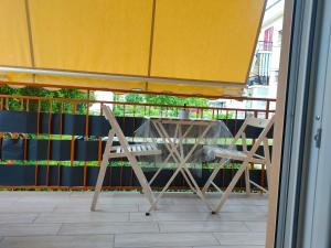 un balcón con mesa y 2 sillas bajo una sombrilla en La Fenice, en Agropoli