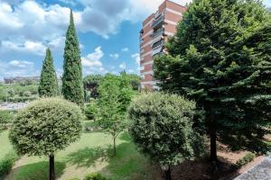a group of trees in a park with a building at RESIDENZA ERES EUR in Rome