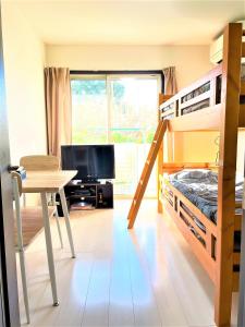 ein Schlafzimmer mit einem Etagenbett, einem Schreibtisch und einem Tisch in der Unterkunft Credo Maison Kamakura - Vacation STAY 10347 in Kamakura