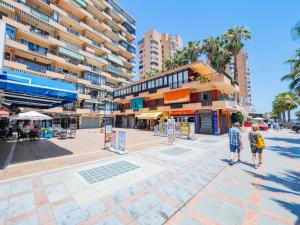 twee mensen die over een straat lopen in een stad bij Cubo's Fuengirola Leisure Port in Fuengirola