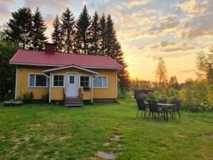 una casa amarilla con una mesa y sillas en el patio en Peaceful house for relaxing, en Oulu