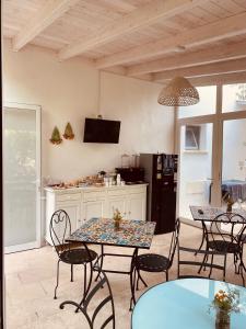 uma cozinha e sala de jantar com mesas e cadeiras em B&B Quasimare em Porto Cesareo