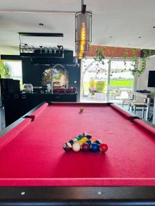 a red pool table with balls on top of it at L'échappée Belle by J&J Durbuy Area in Clavier
