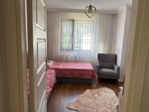 een kleine slaapkamer met een bed en een stoel bij Uzungöl city evleri in Dernekpazarı