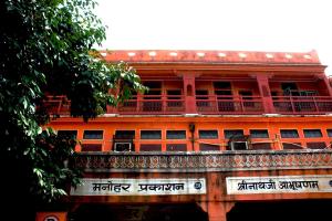un bâtiment orange avec un balcon au-dessus dans l'établissement Friend India, à Jaipur