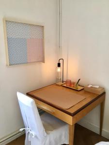 a wooden desk with a lamp and a white chair at Calm, green & birdsong near the city center in Brussels