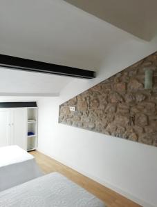 una camera da letto con pareti bianche e un muro in pietra di Coro a Villaviciosa