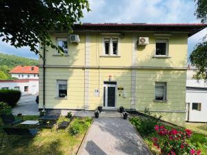 una casa amarilla con un camino que conduce a ella en Lemonwood House, en Postojna