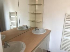 uma casa de banho com 2 lavatórios e um balcão com espelhos em Appartement vue mer, carré d’or ,150 m plages. em Saint-Raphaël