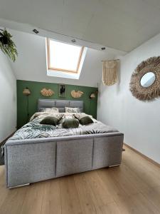 una camera da letto con un letto grande in una stanza con una finestra di L'échappée Belle by J&J Durbuy Area a Clavier