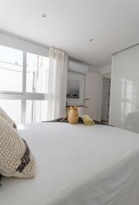 ラ・プラヤ・デ・アルグイネグインにあるCozy and sea views private terrace apartmentの白いベッド(上に2袋のカバン付)