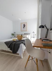 ein Schlafzimmer mit einem Bett mit einem Schreibtisch und einem Stuhl in der Unterkunft Cozy and sea views private terrace apartment in La Playa de Arguineguín