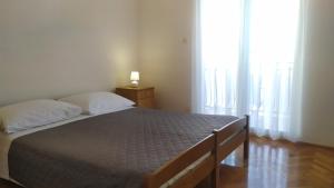 a bed in a room with a large window at Apartments Samodol in Vodice