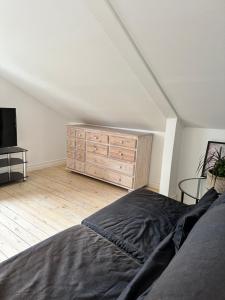 a bedroom with a bed and a wooden dresser at Mysiga lägenheter i Kalmar centrum in Kalmar