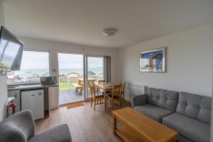 a living room with a couch and a kitchen with a table at Lundy Sea View Villa - Mobility friendly in Bideford