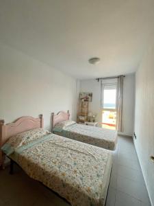 2 camas en una habitación con ventana en Apartment-Duplex, El Medano, en El Médano