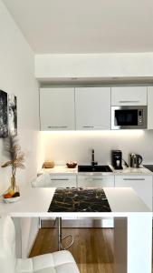 eine Küche mit weißen Schränken und einer weißen Arbeitsplatte in der Unterkunft Angels apartment in Bari