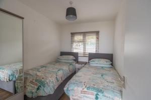 a bedroom with two beds and a window at Lundy Sea View Villa - Mobility friendly in Bideford