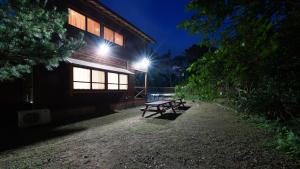 - une table de pique-nique devant un bâtiment la nuit dans l'établissement Villa Tora, à Onna