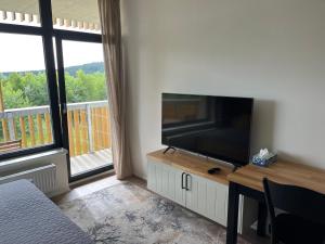 uma sala de estar com uma televisão de ecrã plano e uma mesa em Apartmán na Zadově em Stachy