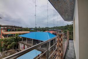 een uitzicht vanaf het balkon van een gebouw met een blauw dak bij OYO Flagship 14426 V Knot Residency in Garacherāma