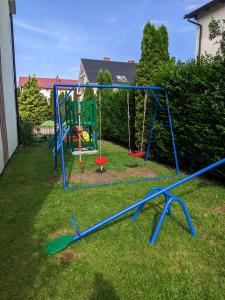 un parque infantil en el patio trasero de una casa en DELFIN Wynajem Pokoi en Ostrowo