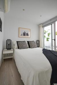 a large white bed in a room with a window at Luminoso loft recién reformado in La Playa de Arguineguín +37 photos