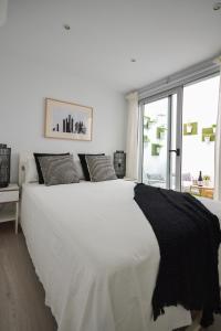 a large white bed in a room with a window at Luminoso loft recién reformado in La Playa de Arguineguín