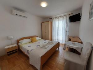 1 dormitorio pequeño con 1 cama y 1 silla en Apartmani Rahela en Vodice