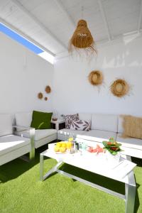 ラ・プラヤ・デ・アルグイネグインにあるLuminoso loft recién reformadoのリビングルーム(白い家具、緑のカーペット付)
