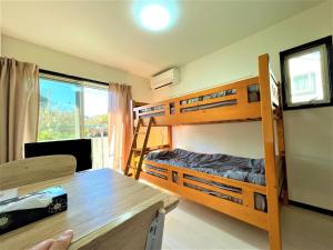 1 Schlafzimmer mit Etagenbetten, einem Schreibtisch und einem Tisch in der Unterkunft Credo Maison Kamakura - Vacation STAY 10347 in Kamakura