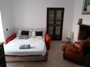 a bedroom with a bed and a chair at Casa Al Vino sul Vesuvio in Pollena Trocchia