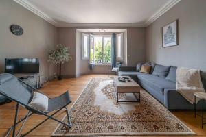 a living room with a blue couch and a tv at Le Rue Neuve - Appartement Calme et lumineux in Vichy