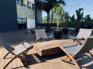 un patio con 2 sillas, una mesa de madera y 2 sillas en The Green Hill com piscinas em Praia Brava en Itajaí