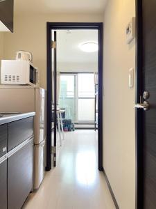 a door leading into a kitchen with a microwave at Credo Maison Kamakura - Vacation STAY 10395 in Kamakura