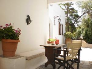 a porch with a table and chairs and plants at Bungalows Svoronos in Naousa