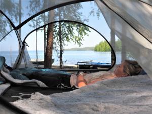 een vrouw in een tent bij het water bij LevonMajat in Joensuu