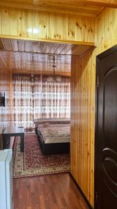 um quarto com uma cama num quarto de madeira em Отель Евразия em Cholpon-Ata