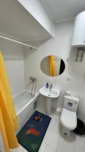 a bathroom with a sink and a toilet and a tub at Отель Евразия in Cholpon-Ata